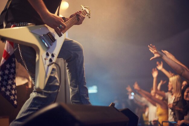 Musicien de concert guitare et rock sur scène pour une fête de foule ou un concert de festival dans la nuit avec le drapeau américain Groupe d'artistes professionnels et festival de musique pour événement pour talent musique solo et performance