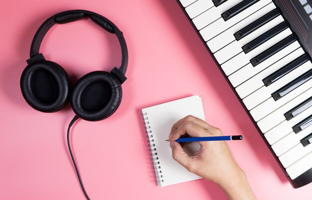 Musicien écrit sur un ordinateur portable avec un espace copie studio rose