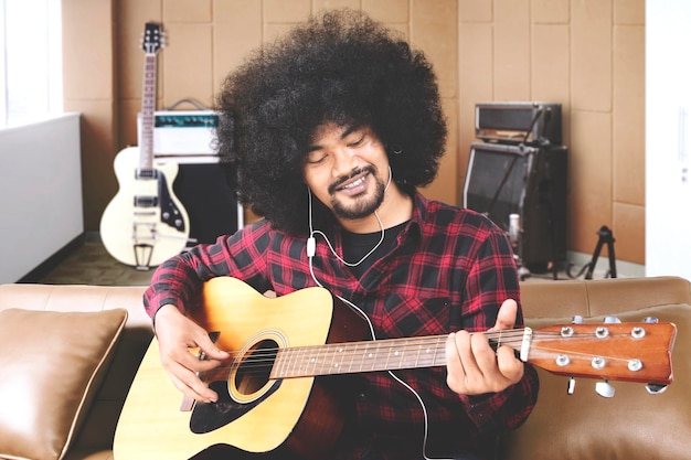 Un musicien joue de la guitare en studio d'enregistrement