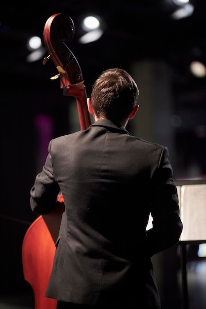 Photo le musicien joue sur scène sur la contrebasse vue arrière depuis l'arrière du bassiste