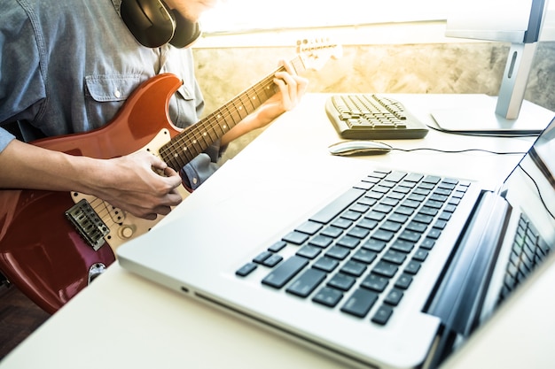 Musicien professionnel enregistrement guitare électrique en studio numérique à la maison.