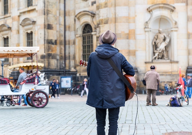 Musicien de rue avec une guitare dans la vieille ville européenne.