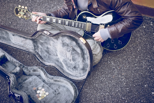 Musicien de rue jouant de la guitare sur le terrain