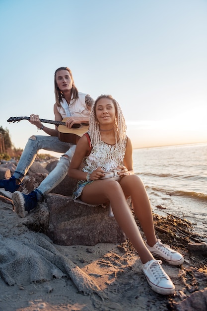 Des musiciens créatifs. Couple de musiciens inspirés créatifs jouant leur chanson préférée près de la mer