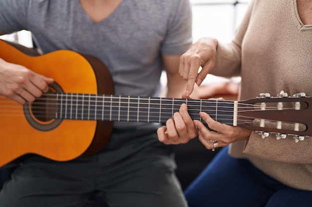 Musiciens homme et femme ayant une leçon de guitare classique au studio de musique