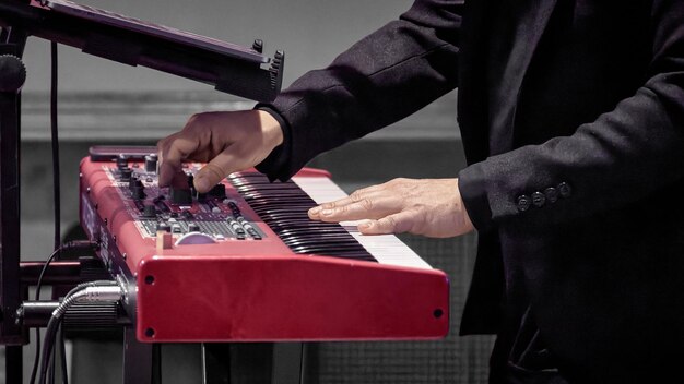 musiciens la main sur les touches d'un piano à électrode rouge