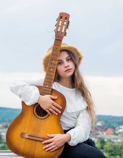 La musique alternative est ma vie enfant avec un instrument à cordes acoustiques amusez-vous sur un guitariste de fête ou un chanteur guitariste avec une fille de guitare jouant de la musique country à l'école de musique