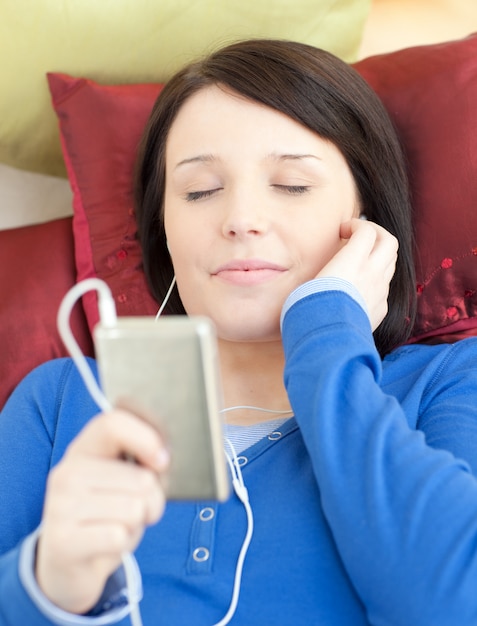 Musique écoute jeune femme brune allongée sur un canapé