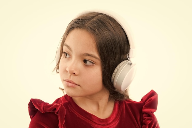 La musique est tellement amusante petite fille en robe rouge enfance et bonheur petit enfant dans les écouteurs musique écoutant ebook audio éducation enfant mode et beauté bonne fête des enfants