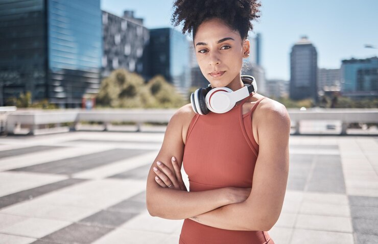 Photo musique fitness et femme noire dans un portrait de ville pour l'exercice d'entraînement ou la motivation d'entraînement santé mentale et bien-être visage d'un athlète sportif avec technologie d'écouteurs pour abonnement audio