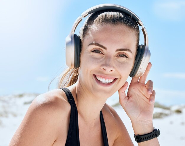 Musique fitness et femme à la plage pour faire de l'exercice bien-être et entraînement cardio tout en écoutant la radio Entraînement de podcast et portrait de fille se détendre sourire et profiter de la piste audio de motivation pour courir