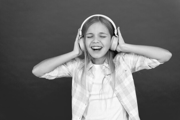 La musique toujours avec moi Une petite fille écoute une chanson avec un casque Chaîne de station de radio en ligne Concept de loisirs Petite fille écoute de la musique avec un casque moderne Obtenez un abonnement à un compte de musique Profitez du concept de musique