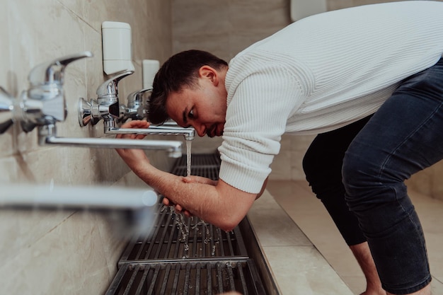 Un musulman faisant ses ablutions. Purification religieuse rituelle des musulmans avant d'accomplir la prière. Le processus de nettoyage du corps avant la prière.