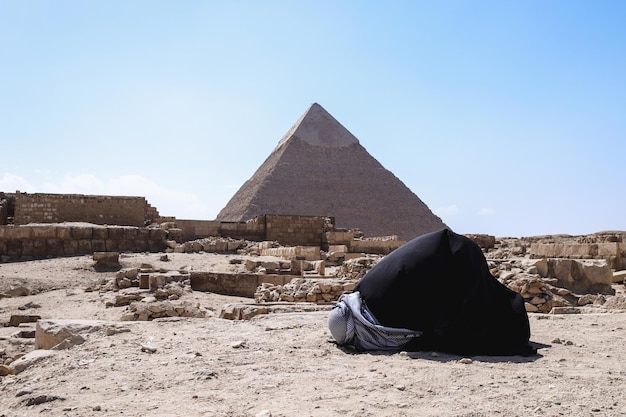 Un musulman priant en posture sujud dans le désert