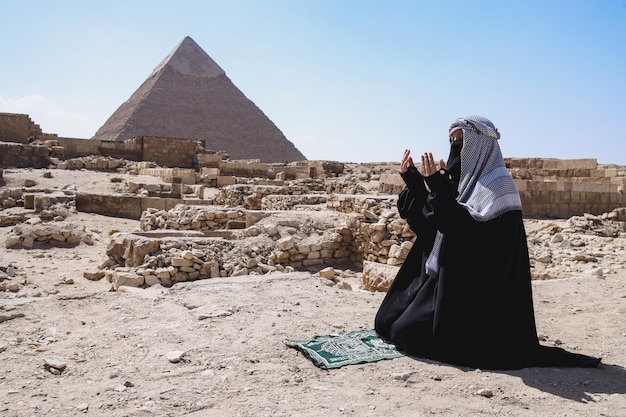 Un musulman avec des vêtements de robe priant dans le désert