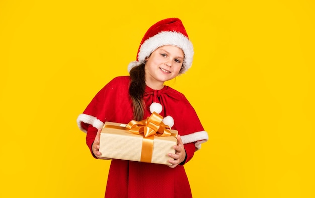 My happy day Xmas gift shopping Little girl Santa hat hold gift box Kid hold present box fond jaune Paquet cadeau Joyeux Noël et joyeuses fêtes Vacances d'hiver Concept de liste de souhaits