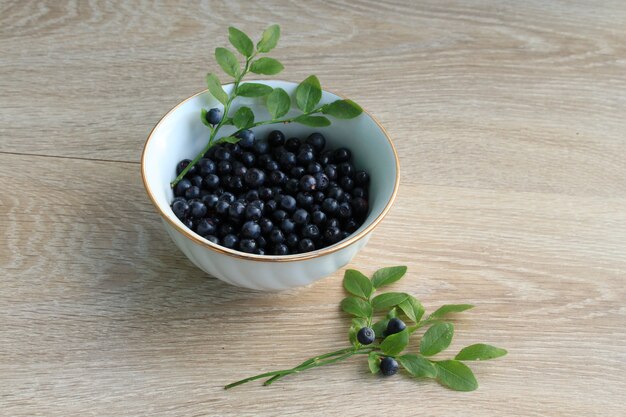 Myrtille dans un bol en céramique isolé sur blanc. Gros plan de bleuets frais, concept de nutrition alimentation saine. Myrtille biologique mûre, repas végétalien. Fond de bleuets juteux.