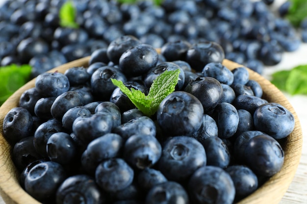 Myrtilles mûres savoureuses à la menthe dans un bol sur la table se bouchent