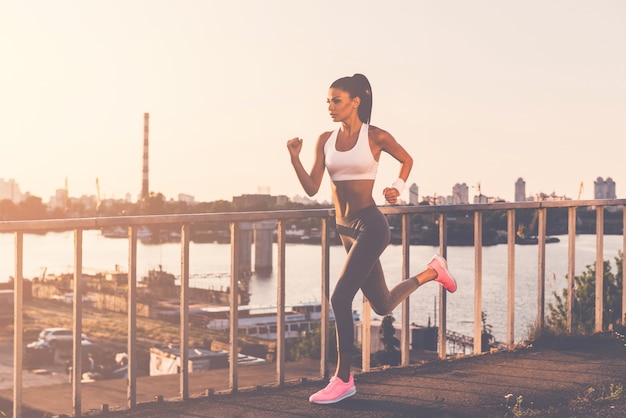 N'abandonnez jamais et continuez d'avancer ! Toute la longueur de la belle jeune femme en vêtements de sport