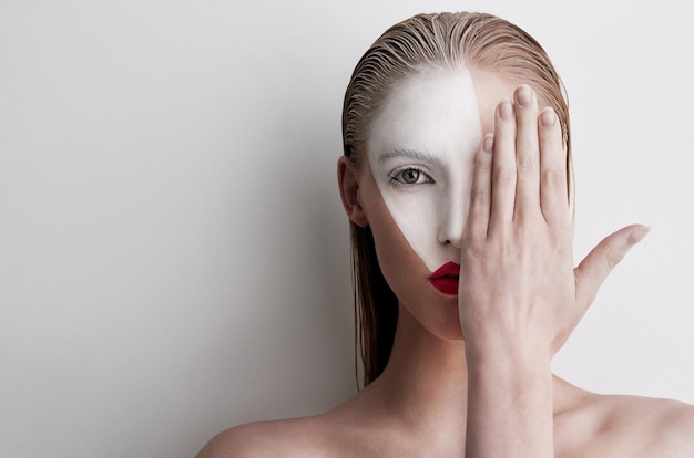 N'ayez Pas Peur De Vous Montrer Photo D'une Belle Femme Portant De La Peinture Faciale Et Du Rouge à Lèvres Sur Un Fond Uni