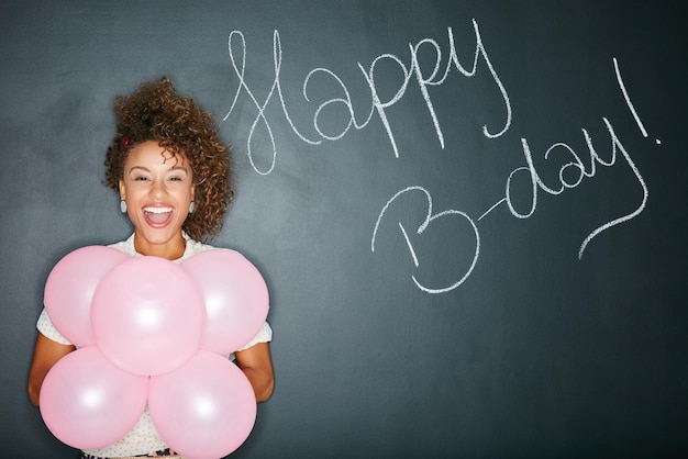 Photo ce n'est pas une partie sans moi portrait en studio d'une jolie jeune femme tenant des ballons avec les mots joyeux anniversaire écrits sur un fond gris