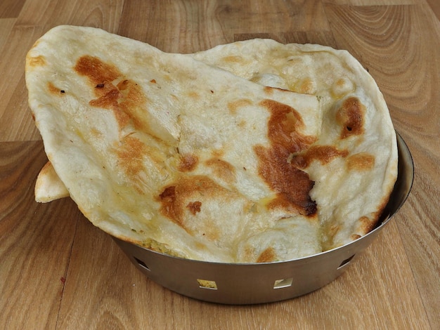 Naan au beurre isolé sur un fond en bois rustique mise au point sélective