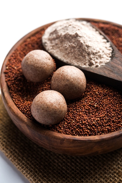 Nachni laddu ou Ragi laddoo ou boules faites avec du millet, du sucre et du ghee. C'est un aliment sain de l'Inde. Servi dans un bol ou une assiette avec du cru entier et de la poudre. Mise au point sélective