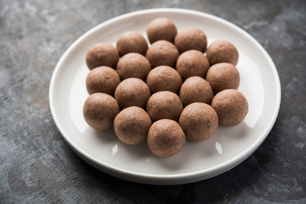 Nachni laddu ou Ragi laddoo ou boules faites avec du millet, du sucre et du ghee. C'est un aliment sain de l'Inde. Servi dans un bol ou une assiette avec du cru entier et de la poudre. Mise au point sélective