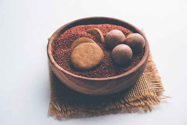 Nachni ou Ragi laddu et biscuits ou biscuits à base de millet, de sucre et de ghee. C'est un aliment sain de l'Inde. Servi dans un bol ou une assiette avec du cru entier et de la poudre