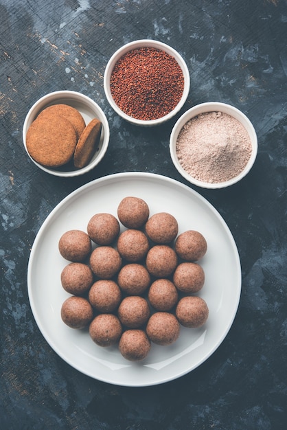 Nachni ou Ragi laddu et biscuits ou biscuits à base de millet, de sucre et de ghee. C'est un aliment sain de l'Inde. Servi dans un bol ou une assiette avec du cru entier et de la poudre