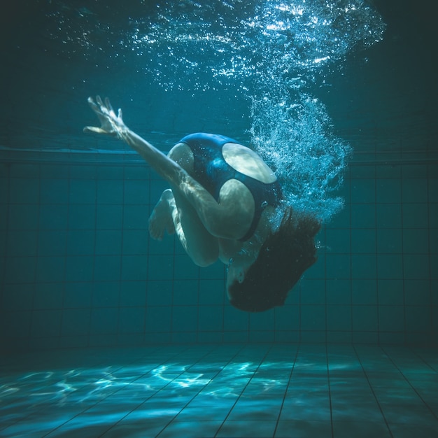 Nageur athlétique faisant un saut périlleux sous l&#39;eau