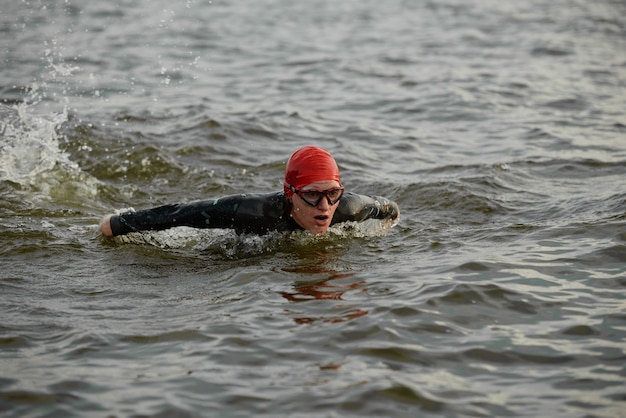 Nageuse en maillot de bain et lunettes ayant un entraînement sportif en mer à l'extérieur