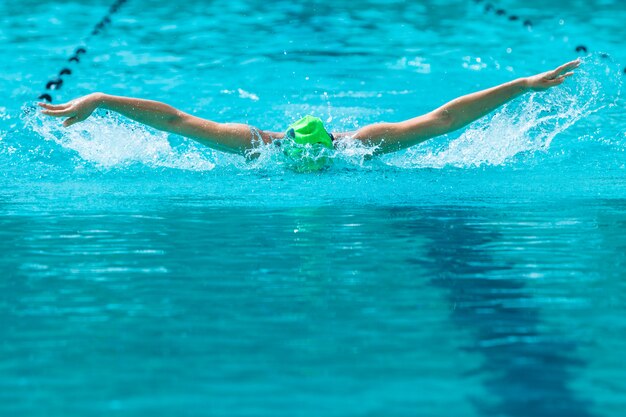 Une nageuse travaillant sur son coup de papillon nage dans une piscine locale