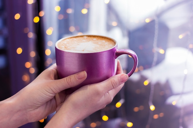 Nands femmes tenant une tasse de café lilas sur dark