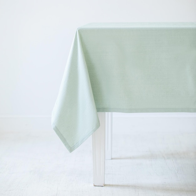 Nappe décorative vert clair sur une table sur un fond blanc