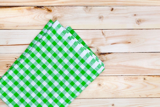 Photo nappe verte sur table en bois, vue du dessus