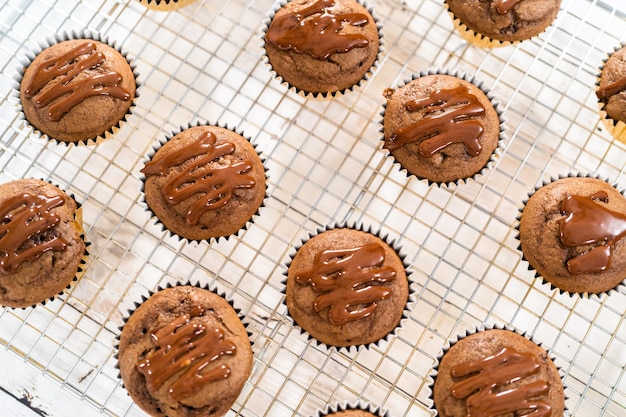 Photo napper de ganache au chocolat sur des cupcakes au chocolat et aux framboises