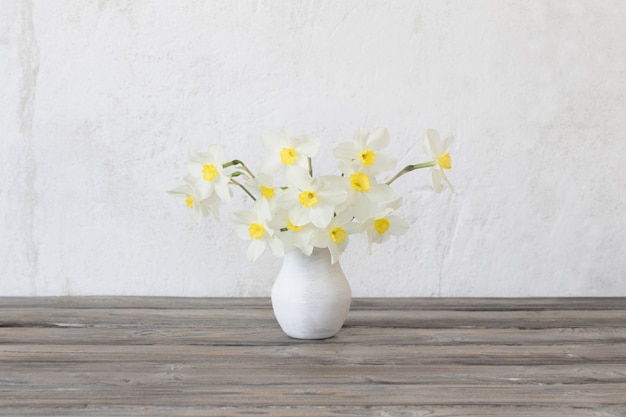 Narcisse dans un vase sur table en bois