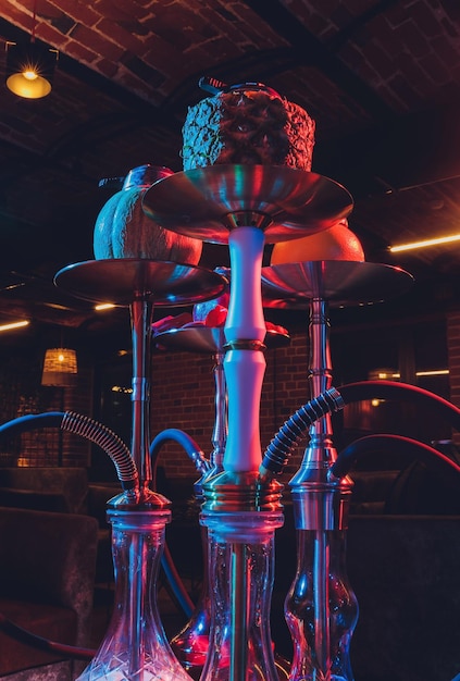 Narguilé chicha rouge avec de la fumée et des étincelles rouges sur fond d'art de brique de table en bois Concept de chicha