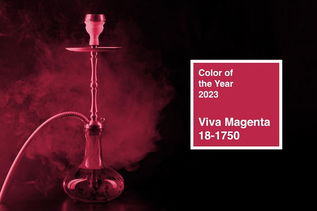 Narguilé moderne avec fumée dans la lumière du club sombre Couleur de l'année 2023 viva magenta