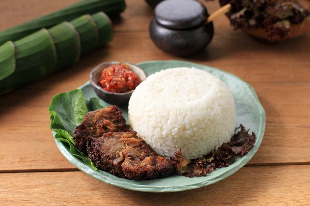 Nasi Empal ou Gepuk est de la viande frite indonésienne aux herbes traditionnelles et aux épices. Il a un goût sucré, savoureux, tendre et délicieux. Habituellement servi avec du sambal et du riz
