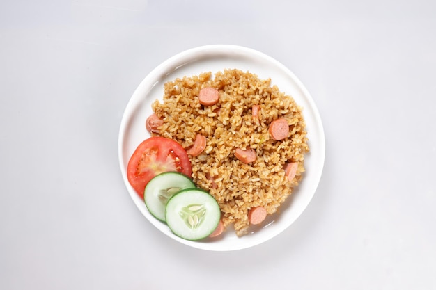 Nasi Goreng Sosis est du riz frit avec des saucisses garnies de tranches de concombre frais et de tomates.