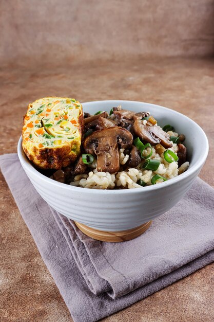 Nasi jamur Champignon de riz ou risotto au riz et aux champignons servi avec omelette roulée