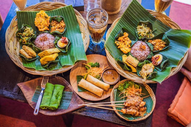 Nasi lemak Nasi campur riz balinais indonésien avec beignet de pommes de terre sate lilit tofu frit épicé œufs durs et cacahuètes