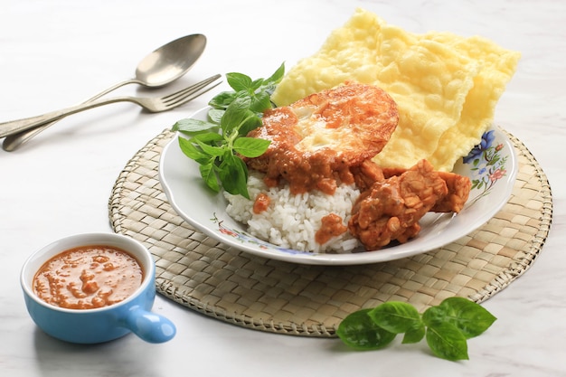 Nasi Pecel Madiun avec œuf et tempeh frit. Pecel est une sauce aux arachides épicée typiquement de Java oriental