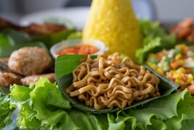 Photo nasi tumpeng cuisine indonésienne riz jaune sur feuille de bananier