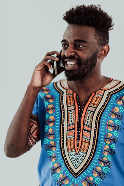 Natif du Soudan Africain mâle utilisant un smartphone isolé sur fond blanc. Photo de haute qualité