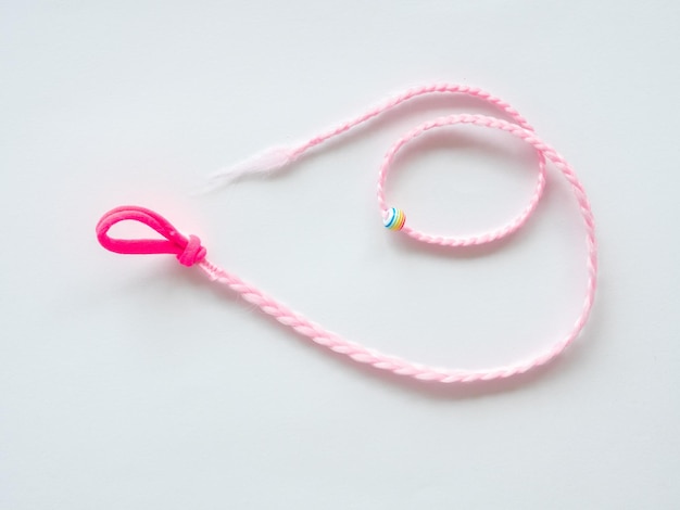 Natte de kanekolon rose attachée à une bande élastique un accessoire pour les coiffures d'enfants