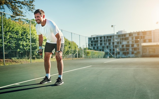 La nature d'arrêt et de pivotement du sprint du tennis peut causer des blessures Photo d'un jeune homme sportif tenant son genou de douleur tout en jouant au tennis sur un court de tennis