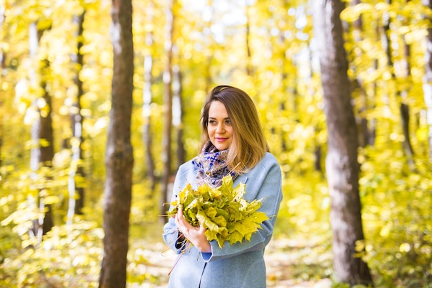 Nature, beauté, concept de personnes - portrait de jolie jeune femme avec un bouquet coloré de jaune